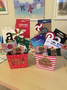 several christmas gift baskets on a table in front of pictures and cards with the word merry written on them