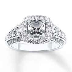 a white gold ring with diamonds on the sides and a center stone in the middle