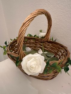 a wicker basket with white flowers and greenery