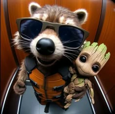 a raccoon wearing sunglasses and holding a baby grooter in his arms