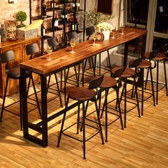 a long table with chairs and wine glasses on it in front of a brick wall