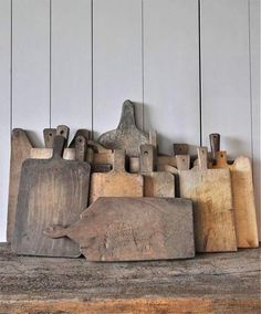 several wooden cutting boards sitting on top of a table