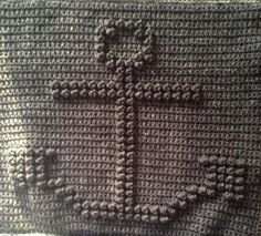 a crocheted pillow with a cross on it