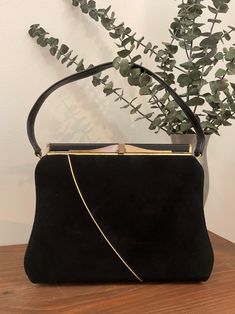 1960s A Life Stride Black Top Handle Handbag, Vintage Black Suede/Vinyl Purse, Vintage Accessory  Stunning 1960s black suede and black vinyl top handle handbag made by a life stride handbag. The front body of the handbag is black suede with a gold decorative strip running down the front and onto the bottom of the bag. Both sides and back of the bag are black vinyl. It features a black single vinyl handle strap. There is gold tone metal hardware with a thumb lift closure that works well and closes tightly. Opens to a black faille lining with one open pocket behind a nylon zippered pocket. Attached a life stride handbag label. Stamped 84005 820Z42. Protective feet are on the bottom of the bag. Beautiful vintage condition *the front exterior is immaculate.  The back exterior has some surface Vintage Black Bag For Vintage Events, Retro Black Bags For Vintage Events, Vintage Black Rectangular Bag For Formal Occasions, Black Vintage Bags For Vintage Events, Vintage Black Rectangular Shoulder Bag, Rectangular Retro Shoulder Bag For Vintage Events, Vintage Black Satchel Shoulder Bag, Retro Shoulder Bag With Gold-tone Hardware, Vintage Evening Shoulder Bag With Gold-tone Hardware