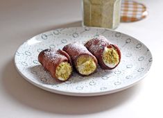 three pastries on a plate with powdered sugar