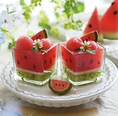 slices of watermelon and kiwi on a plate with flowers in the background