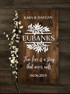 a wooden sign with the words eubanks on it next to some white flowers