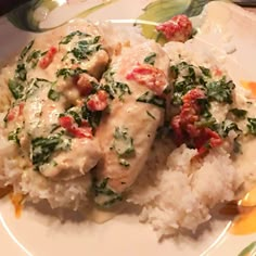 two pieces of chicken with spinach and rice on a plate