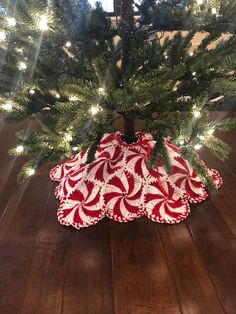 a small christmas tree with red and white candy canes on it's bottom