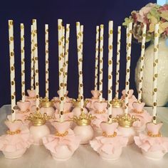 there are many candles that have been decorated with pink flowers and gold trimmings