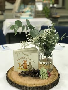 there is a card and some flowers in a vase on top of a tree stump