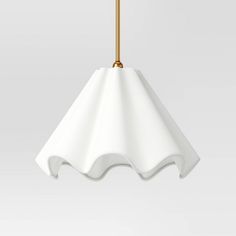 a white lamp hanging from a gold colored cord