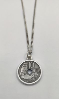 This beautiful vintage 10 Lepta coin from Greece Commonly used in the year : 1912 Turned into a one of a kind pendant In Greek mythology, a little owl (Athene noctua)  Traditionally represents or accompanies Goddess Athena. Because of such association, the bird  often referred to as the "owl of Athena". has been used as a symbol of knowledge, wisdom and perspicacity. One side shows an owl on amphora left of centre hole  Lettering: 10 ΛΕΠΤΑ CH.Pillet Translation: 10 Lepta CH.Pillet  Reverse: Crow Vintage Coin Pendant Jewelry, Vintage Charm Pendant Coin Necklace, Vintage Pendant Coin Necklace With Charm, Handmade Antique Coin Necklace With Round Pendant, Medallion Coin Necklace With Vintage Charm As A Gift, Vintage Charm Medallion Coin Necklace As Gift, Vintage Medallion Coin Necklace As A Gift, Antique Coin Pendant Necklace As Gift, Vintage Charm Medallion Coin Necklace For Gift