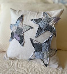 a close up of a pillow on a bed with some pillows in the shape of stars