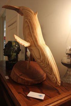 a wooden bird sculpture sitting on top of a table