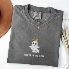 Get into the Halloween spirit with a faithful twist! Our "Jesus is My Boo" embroidered shirt is perfect for Christians looking to celebrate the season with a fun and meaningful message. The design features an adorable ghost with a halo, reminding everyone that Jesus and the Holy Spirit are always with you. Available in a variety of Comfort Colors, this comfortable and stylish shirt is perfect for Halloween festivities, church events, or casual everyday wear. Share your faith with a smile and let Christian Halloween, Faith Apparel, Christian Merch, Faith Clothing, My Boo, Church Events, Jesus Shirt, Christian Tees, Jesus Shirts