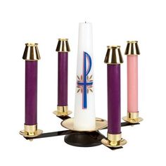 three candles are in the shape of an obelisk and one has a cross on it