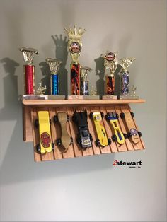 a wooden shelf filled with lots of different types of toy cars on top of each other