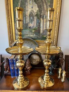 two golden candlesticks sitting on top of a wooden table