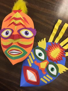 two paper masks are sitting on a table