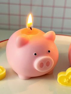 a pink piggy bank sitting on top of a table next to two yellow rubber ducks