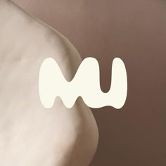 a white object with the letter m on it's back and bottom part, in front of a brown background