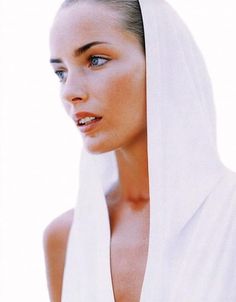 a woman wearing a white shawl and looking off to the side with blue eyes