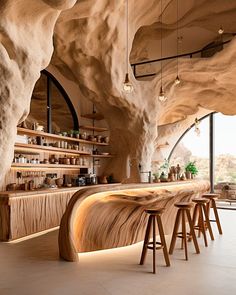 a bar with wooden stools in front of large rocks and shelves filled with bottles