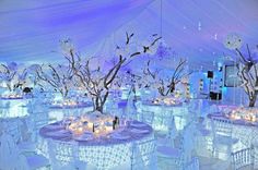 the tables are set up with white linens and centerpieces for an elegant event