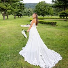 a woman in a wedding dress standing on the grass