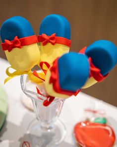 three hats are sitting in a vase with candy on the table next to other items