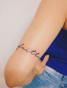 a woman's arm with the word faith written in cursive writing on it