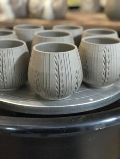 several gray vases sitting on top of a metal tray