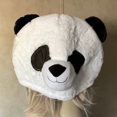 a white and black panda bear hat on top of a mannequin's head