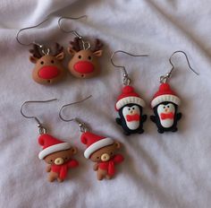 three christmas themed items are displayed on a white sheet, including earrings and pendants