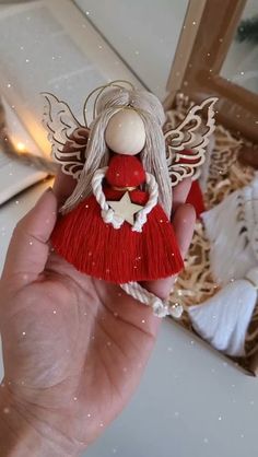 a hand holding a red and white angel ornament