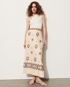 This soft a-line skirt is intricately embroidered in bold blue, rich tan, and soft sand coloring detailing a floral-inspired motif. Complement the high-rise waist with the matching top or a flowy t-shirt. Side-zip closure Length from Highest Point to Hem: 36 1/2" Detailed embroidery throughout Side slits Cotton Poplin Floral Embroidered Flared Dress, Spring Embroidered Beige Skirt, Elegant Summer Skirt With Floral Embroidery, Beige Asymmetrical Maxi Skirt For Spring, Spring Floral Embroidered Flared Skirt Dress, Spring Flared Dress With Floral Embroidery, Spring Floral Embroidered Flared Dress, Spring Dress With Floral Embroidery And Flared Skirt, Spring Beige Long Skirt Dress