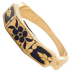 This antique Victorian memory ring is a finely crafted piece, designed in 18-karat gold and adorned with intricate black enamel. The enamel is decorated with a delicate floral design, featuring a "forget-me-not" flower motif. This flower, often associated with remembrance and enduring love, was a popular symbol in Victorian jewelry, adding sentimental and symbolic value to the piece. The outer band of the ring is richly decorated with black enamel, which provides a striking contrast to the warm glow of the gold. The centerpiece of the design is the forget-me-not flower, beautifully rendered in enamel, with its delicate petals symbolizing love, remembrance, and fidelity. The floral design gives the ring a timeless elegance, making it not only a piece of jewelry but also a sentimental keepsa Memory Ring, Forget Me Not Flower, Memorial Ring, Secret Compartment, Shopping Photography, Victorian Rings, Flower Motif, Victorian Jewelry, Forget Me Not