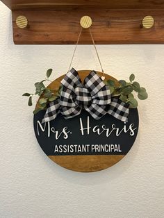 a black and white sign hanging from the side of a wall that says mrs harris assistant principals