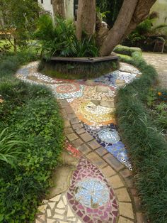 a walkway made out of colorful tiles and plants