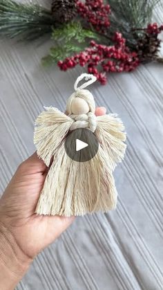 someone is holding an ornament that looks like a tasseled bag with a bow on it