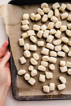 someone is making homemade gnocchini on a sheet of parchment paper with the words, easy homemade gnocchini