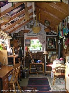 a room filled with lots of clutter and wooden furniture next to an open window