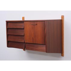 a wooden cabinet with three drawers on the wall