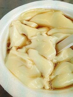 a bowl filled with dumplings sitting on top of a table next to a knife