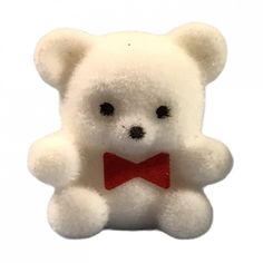 a small white teddy bear with a red bow tie on it's lapel