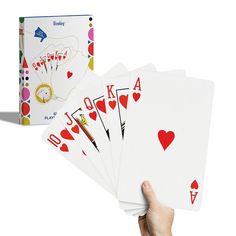 a hand holding four playing cards in front of a white background