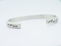 "This floral cuff is a sturdy sterling silver piece, ideal for men and women. Entirely handmade and hand textured with leaves stamps, these open bangles can be made with a 4mm silver wire (€85) or with a 6mm wire(€115). You'll be prompt to select your preferences. BANGLE SIZES To determine your size, you'll need to measure your wrist circumference. XS - Circumference (including opening) 6\" S - circumference (including opening) 6,5\" M - circumference (including opening) 7\" L - circumference (i Sterling Silver Stamped Cuff Bangle, Stamped Sterling Silver Cuff Bracelet, Adjustable Sterling Silver Stamped Cuff Bracelet, Beautiful Arms, Floral Cuff, Bracelet For Her, Custom Bracelet, Open Bangle, Unisex Jewelry