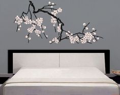 a bedroom with a bed and wall stickers on the walls that are decorated with white flowers