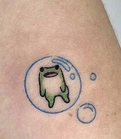 a small tattoo on the back of a person's arm that has a frog in it